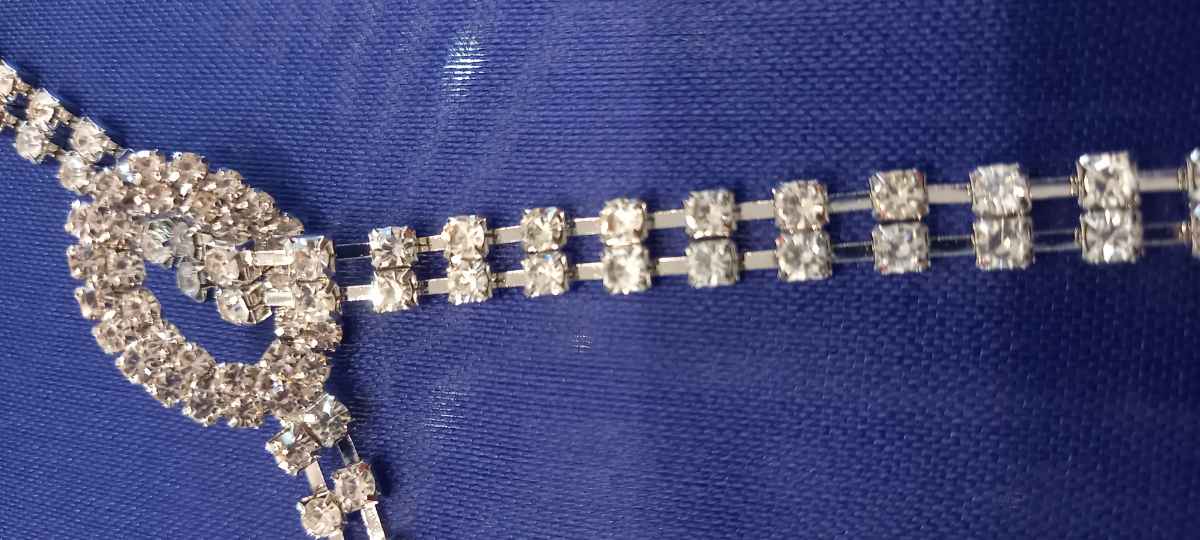 Dettaglio nodo scorrevole e cristalli incastonati con griffe cintura strass argento