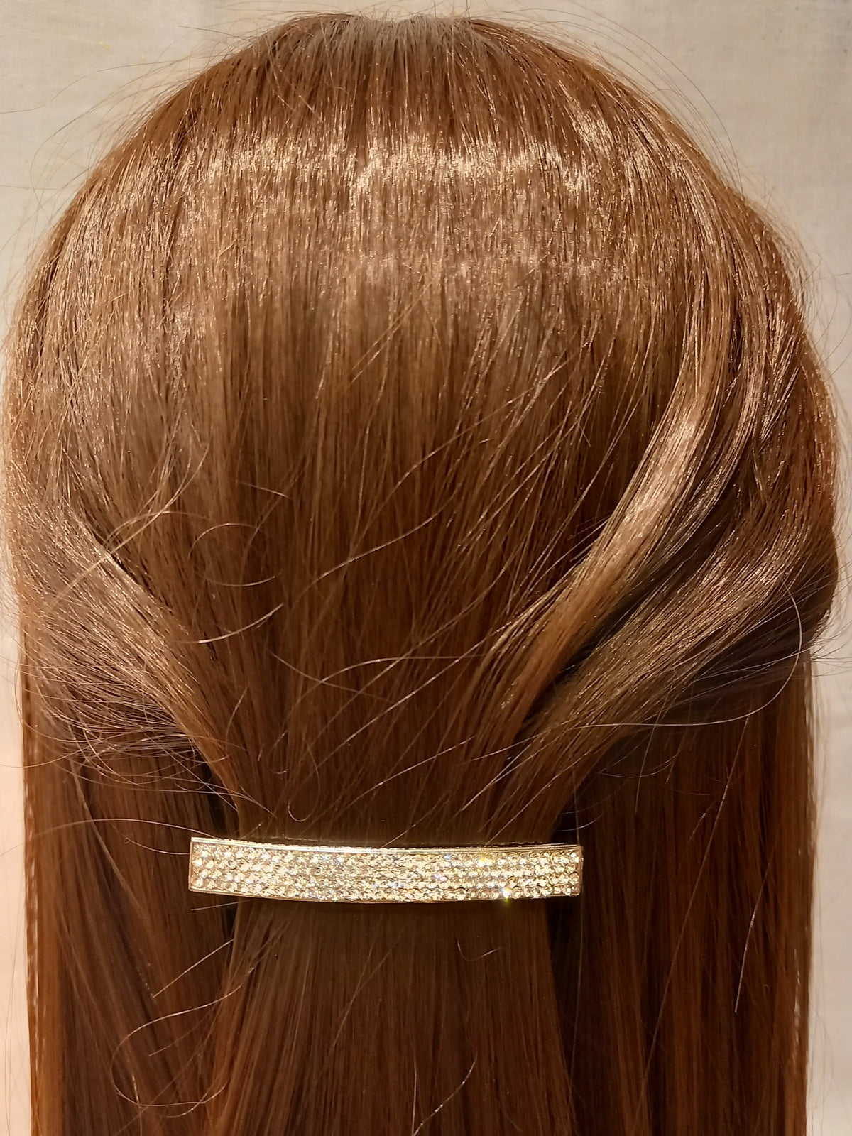 Clip matic rettangolare strass argentata indossata su capelli castani